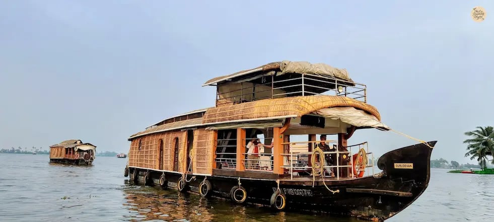 Traditional houseboat cruising on the wide waters of Vembanad Lake in Alleppey, Kerala.