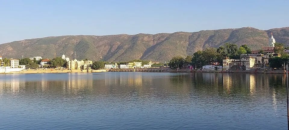 Pushkar Lake in Rajasthan with holy ghats and temples reflecting in calm waters.