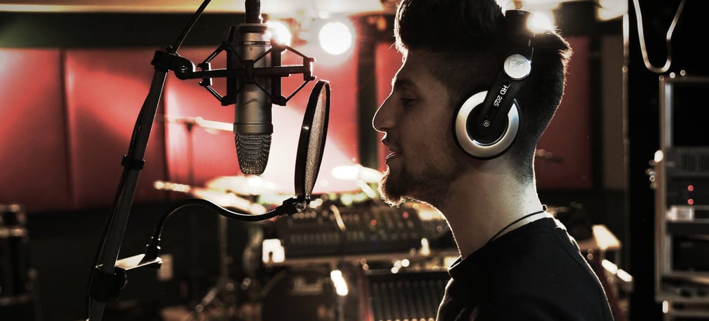 a man in a recording studio with headphones sings