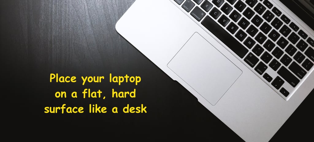 a image showing to place your laptop on a hard flat surface to prevent overheatingg