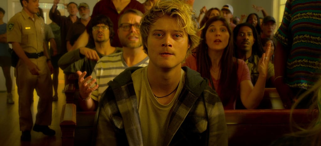 a man in a church pewing chair with a woman in a crowd of people