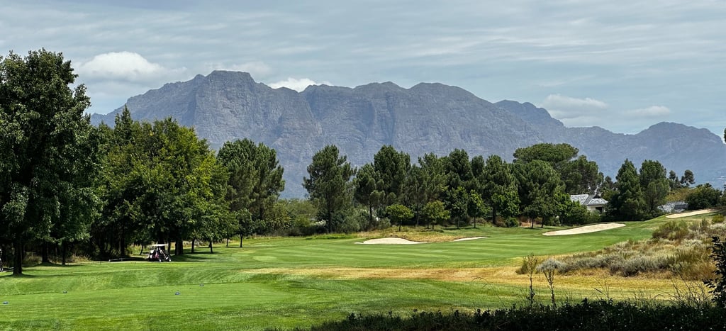 a golf course with a view of the mountains