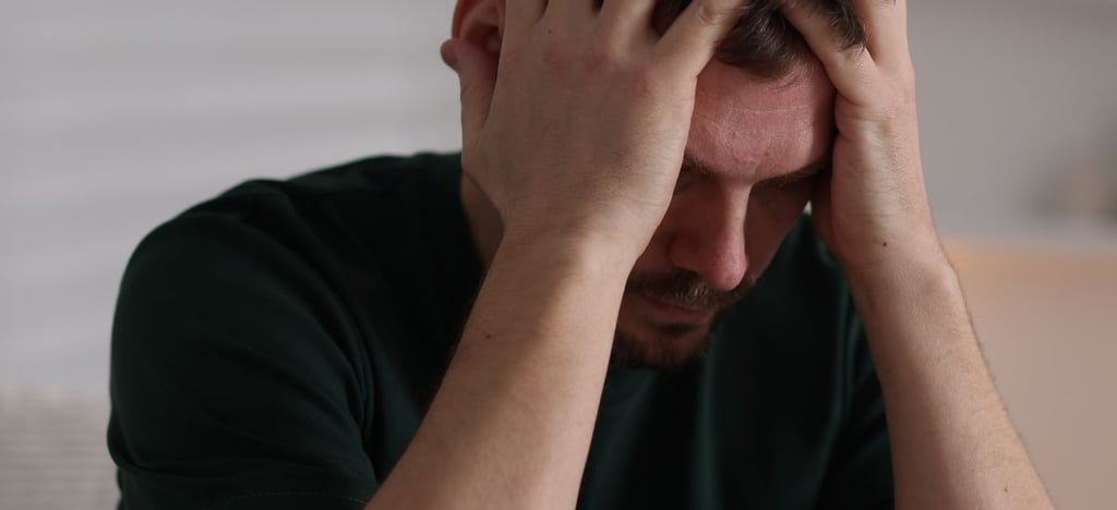 a man with hands to his head in a green shirt