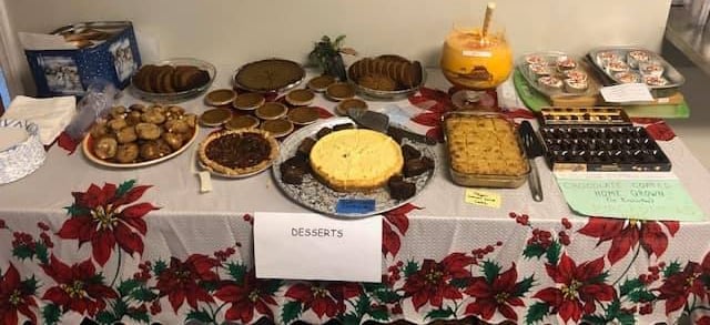 A dessert table spread on a poinsettia tablecloth