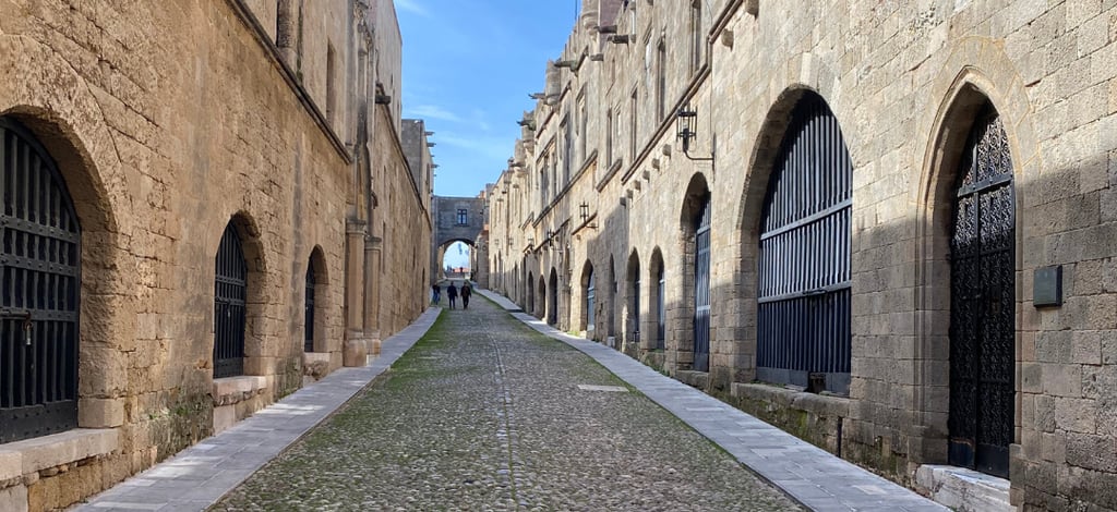 Medieval Street of the Knights with cobblestone path and stone arches in Rhodes Old Town, Greece.
