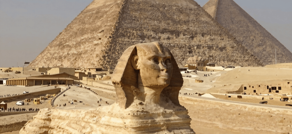 The Great Sphinx of Giza with the Great Pyramid of Khufu in the desert of Egypt.