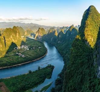 Aerial view of the Li River winding through lush green karst mountains in Guilin, China.
