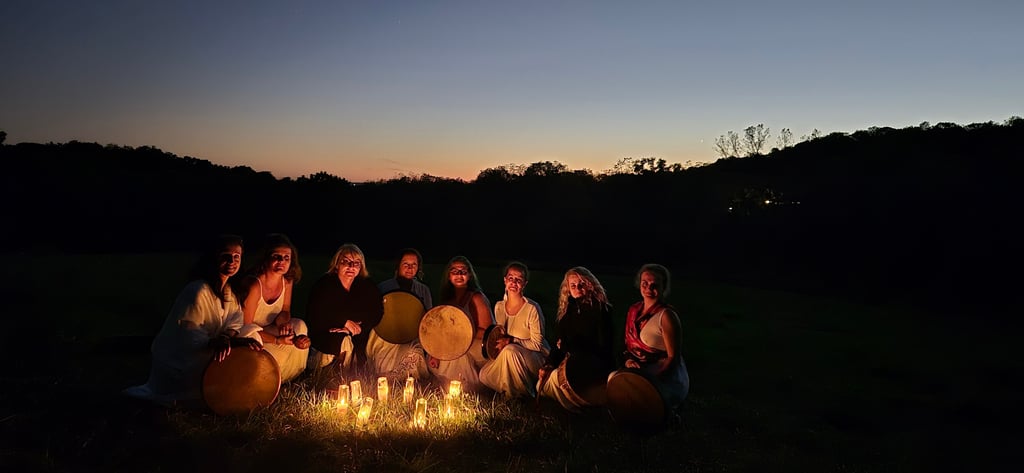 a group of women sitting around a candles at night