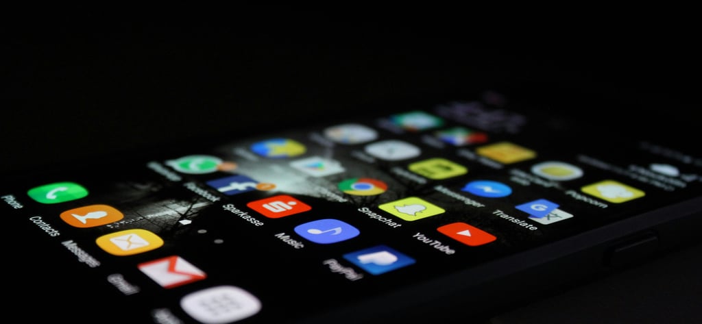 Tampilan dekat layar smartphone dengan berbagai aplikasi, melambangkan manajemen SDM digital dan akses karyawan melalui platf