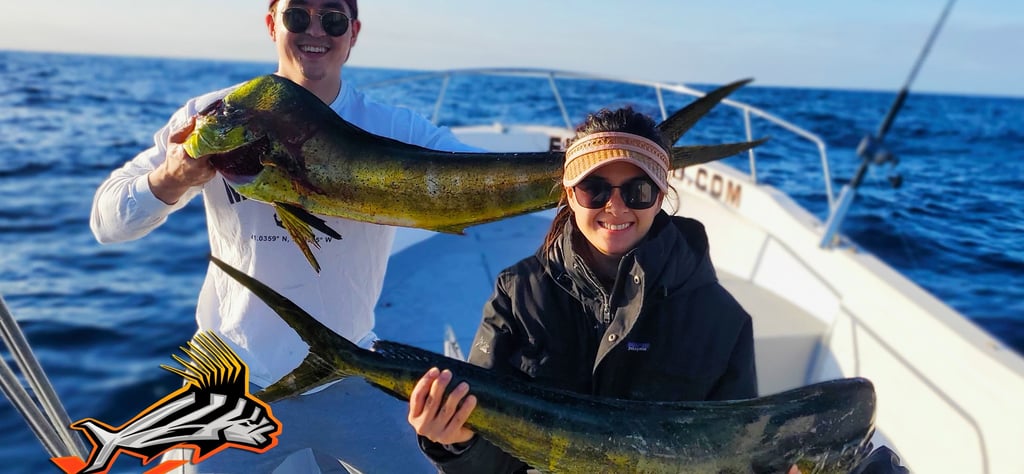 a man and woman holding two fish on a boat
