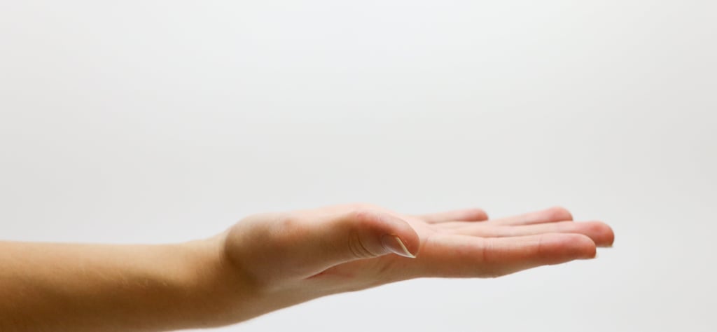 a person's hand is extended and opened  with palm facing up
