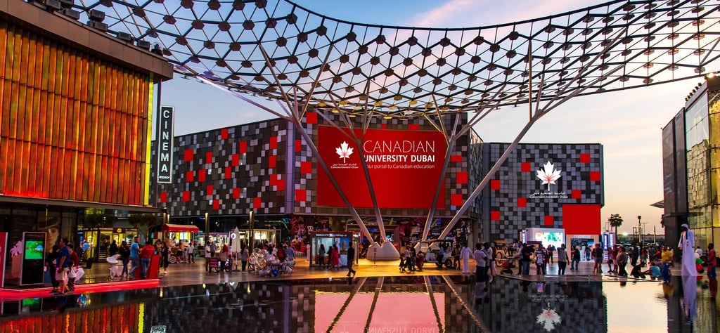 Canadian University Dubai entrance at dusk with large illuminated sign, highlighting the vibrant