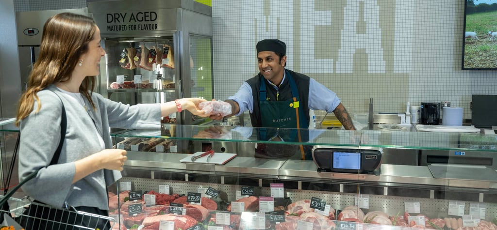 a man and woman in a butcher shop