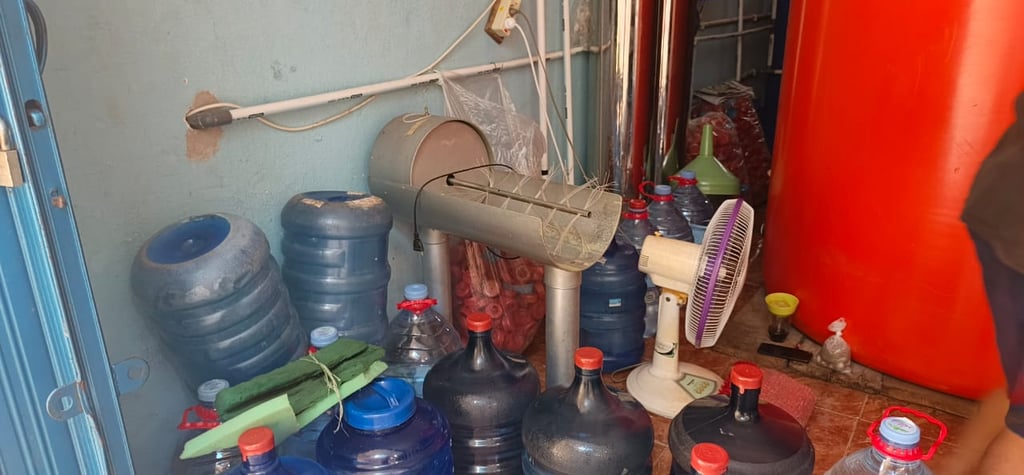 a man standing in front of a bunch of water bottles