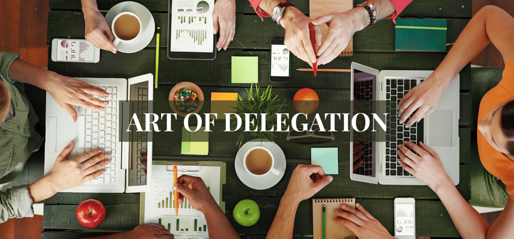 a group of people sitting around a table with laptops