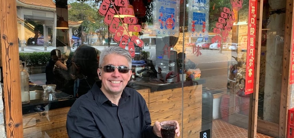 a man sitting on a bench in front of a store