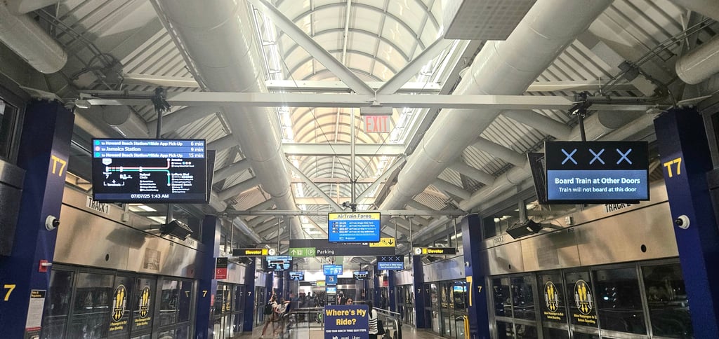 Terminal 7 AirTrain platform at JFK Airport showing route map and LIRR schedule to Manhattan