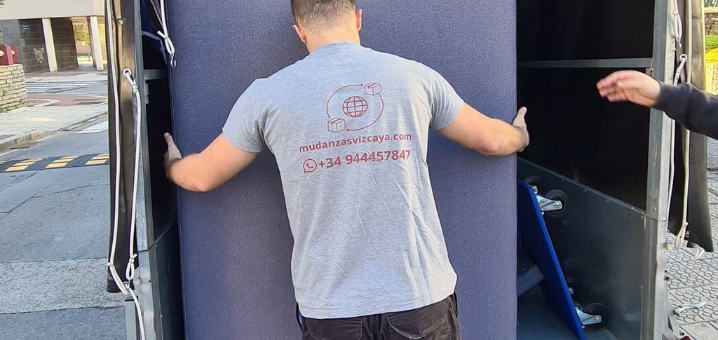 a man is moving a couch into a moving truck