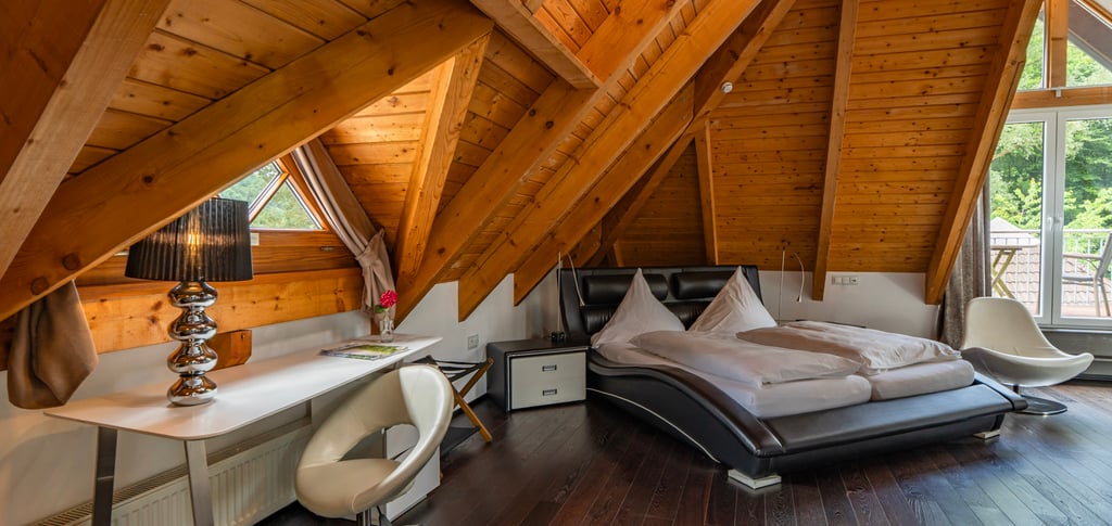Modern eingerichtetes Hotelzimmer im Dachgeschoss mit Holzarchitektur und natürlichem Licht.