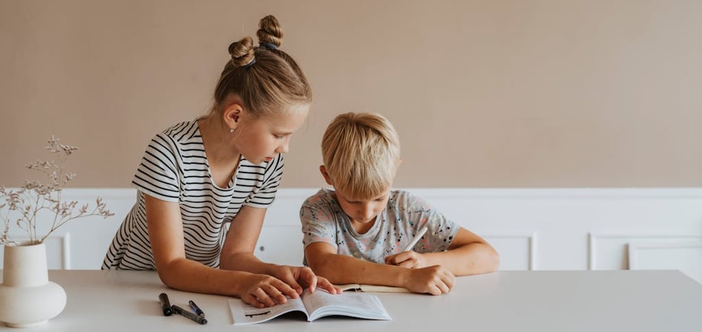A little girl helping a boy study 