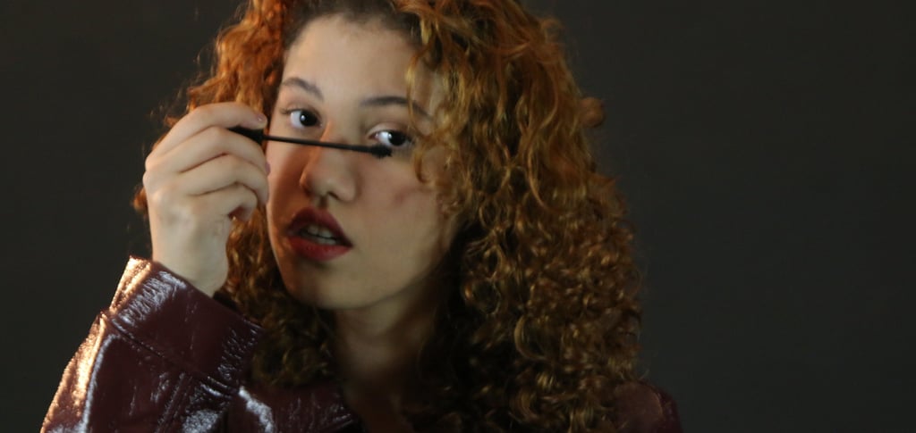 a woman with curly hair and a leather jacket