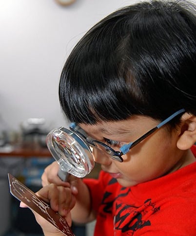 child reading through lens