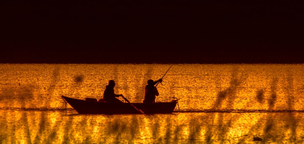 two people fishing on Lake Texoma at sunset