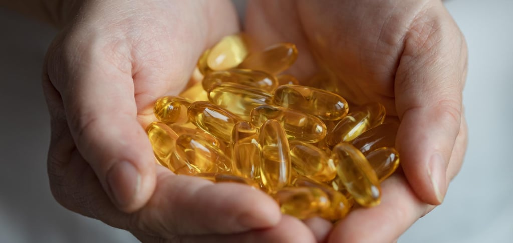 Mano que sostiene cápsulas de Omega 3