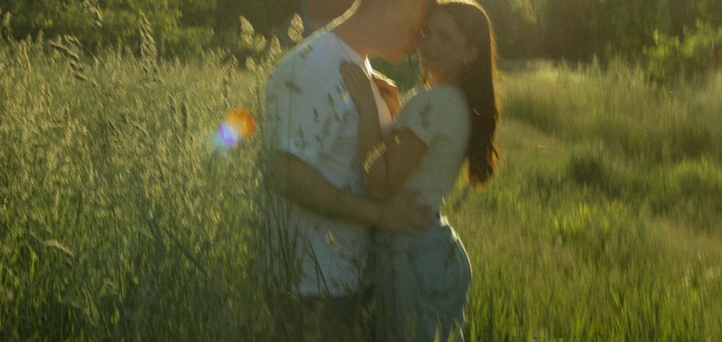 a man and woman kissing in a field