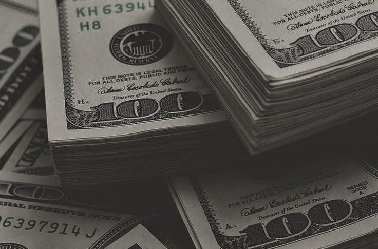 a pile of money bills and bills in front of a pile of money