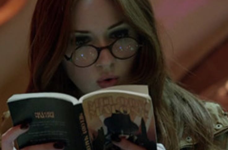 imagem da personagem amy pond da serie doctor who lendo um livro dentro da tardis