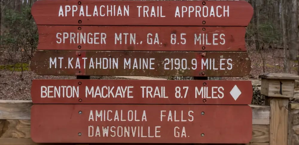 a sign post with a trail marker and a trail marker