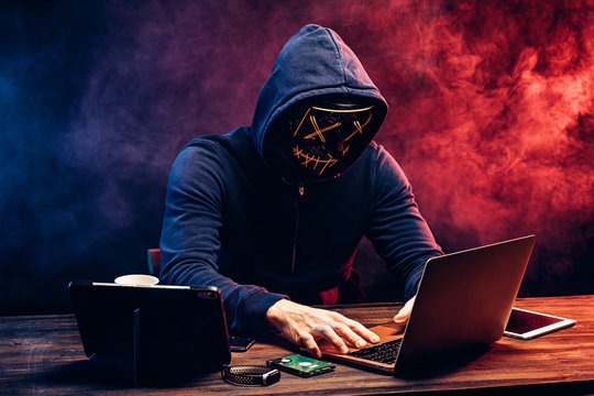 a person in a hoodie with a laptop computer