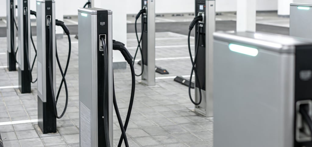 Row of modern electric vehicle charging stations in a bright underground parking garage.