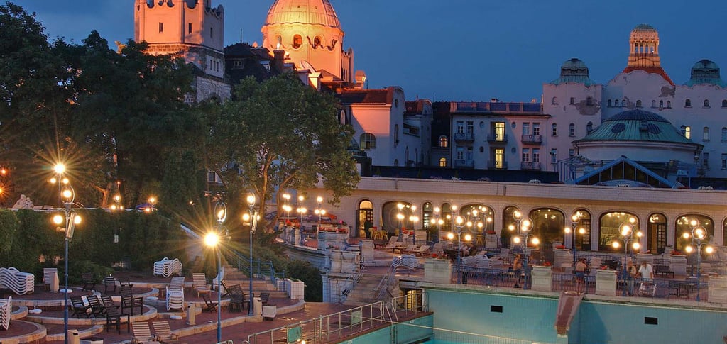 The outdoor thermal pool at Gellert Baths in Budapest illuminated at night with Art Nouveau architecture.