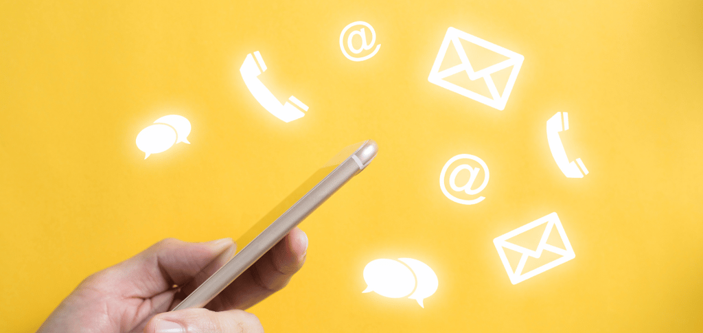 a person holding a cell phone with contact icons floating in the background.