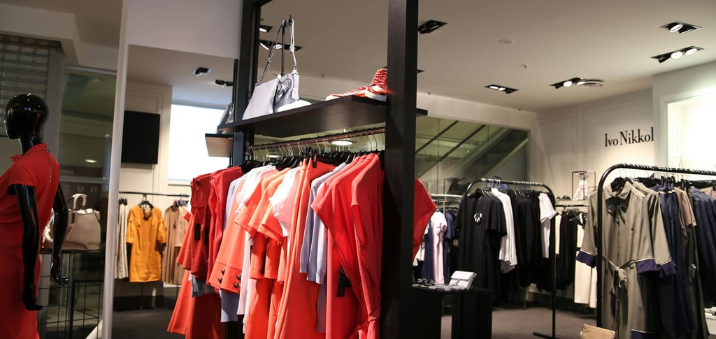 a fashion shop with dresses, outfits and coats on display