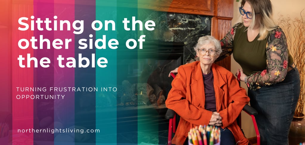 A caregiver comforts an elderly woman in a wheelchair by a fireplace, illustrating senior care services.