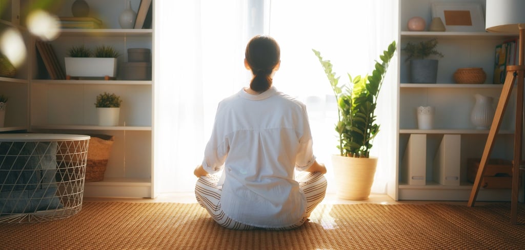 a woman sitting on the floor and looking out the window