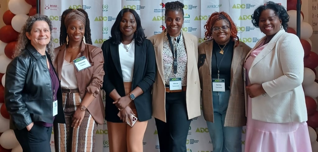 Six female leaders in front of the 2026 Africa Development Conference at Harvard banner smiling.