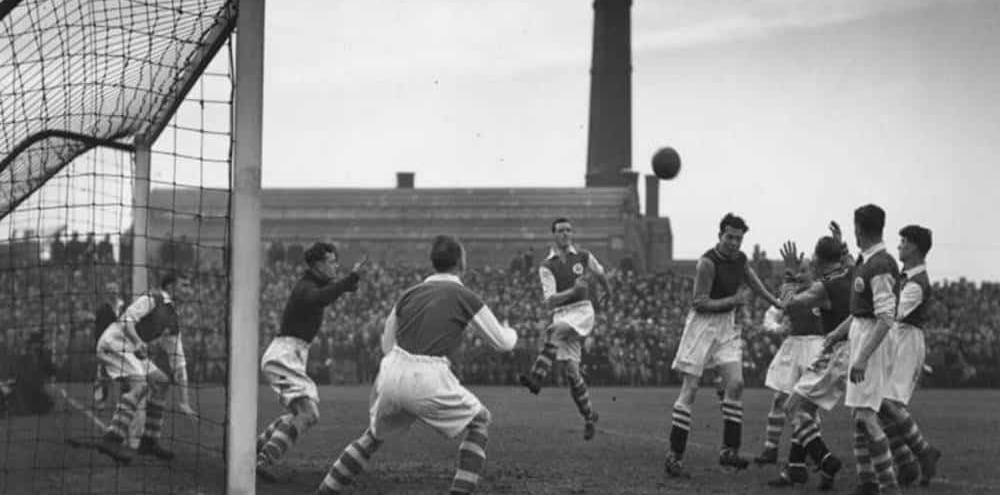 a soccer player is in the middle of a goalie