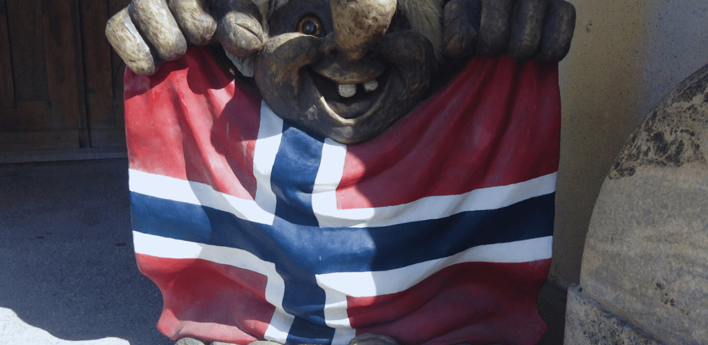 Estátua de um troll segurando a bandeira da Noruega 