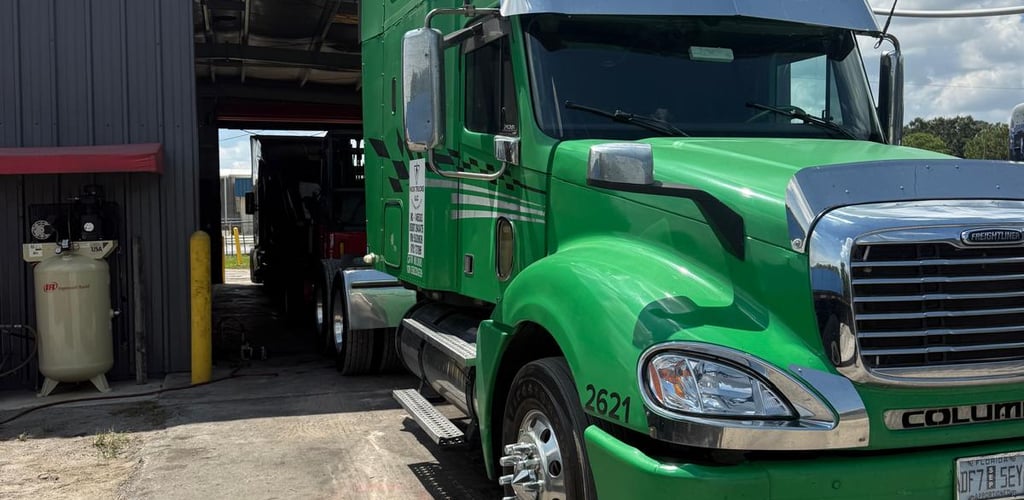 a green semi truck parked in front of a building