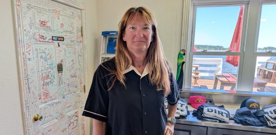 Ellen standing in front of a table with t-shirts on it