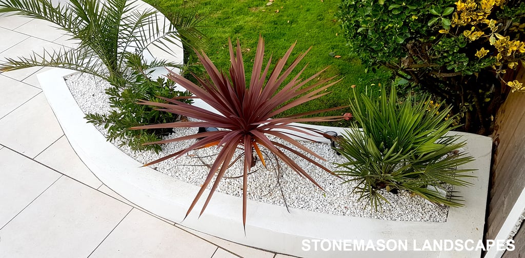Modern chic raised porcelain patio with white rendered walls and planters