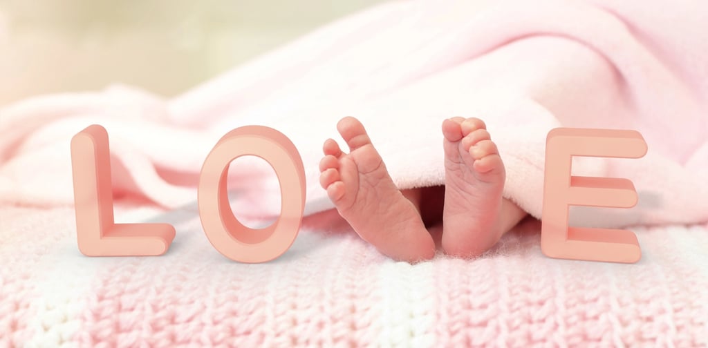 Die Füße eines Babys liegen auf einer Decke mit dem Wort Liebe.