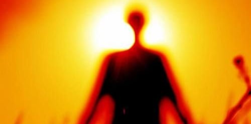 a person walking in a field into the sunset