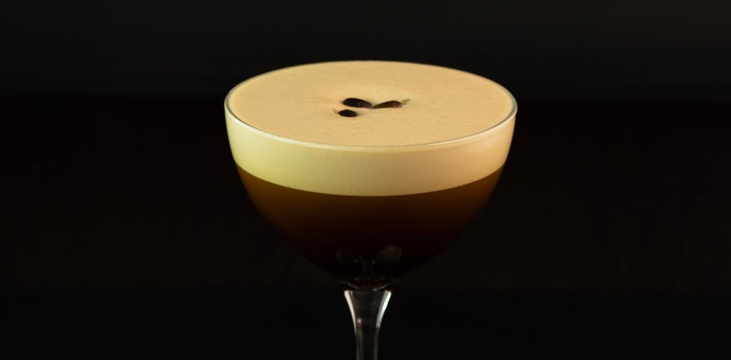 Espresso-Martini-Cocktail mit cremigem Schaum und Kaffeebohnen-Garnitur in einem Coupéglas.