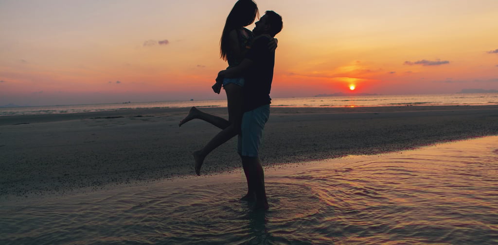 a man and woman kissing on the beach during a sunset on their honeymoon in the dominican republic