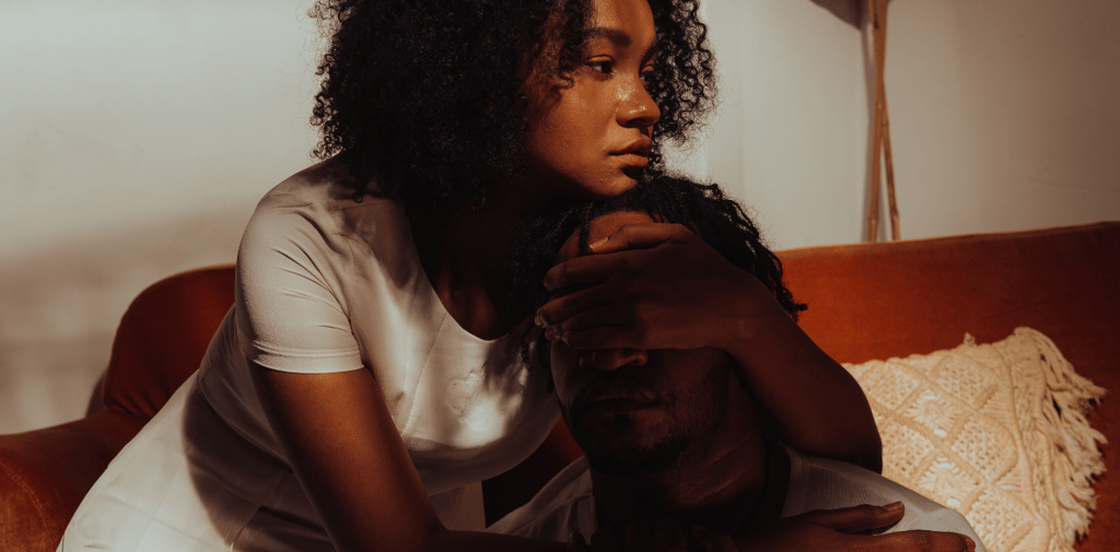 a woman sitting on a couch comforting a friend